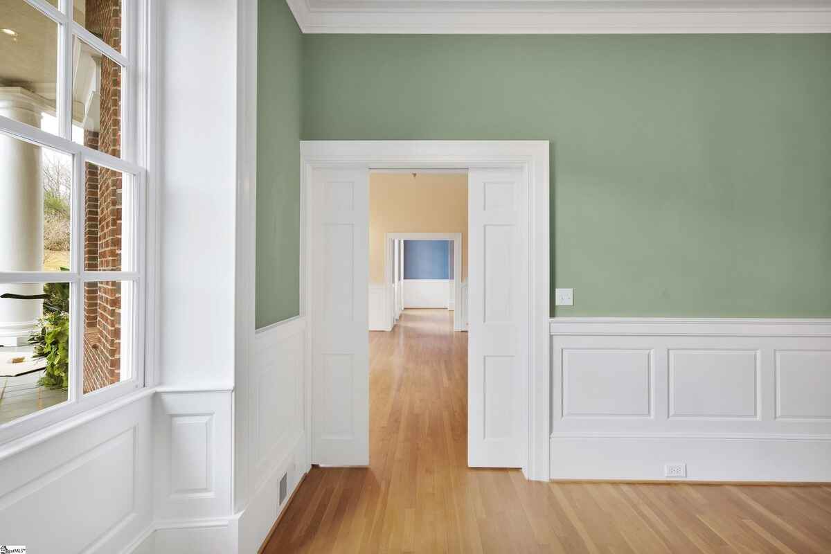 Hallway view showcasing clean lines, detailed molding, and natural light.