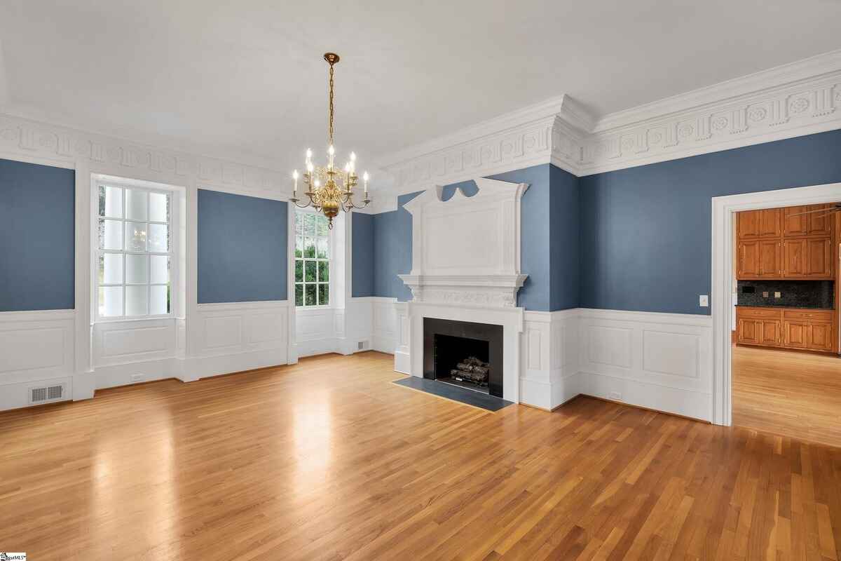 Formal dining room with blue walls, ornate crown molding, and a fireplace.