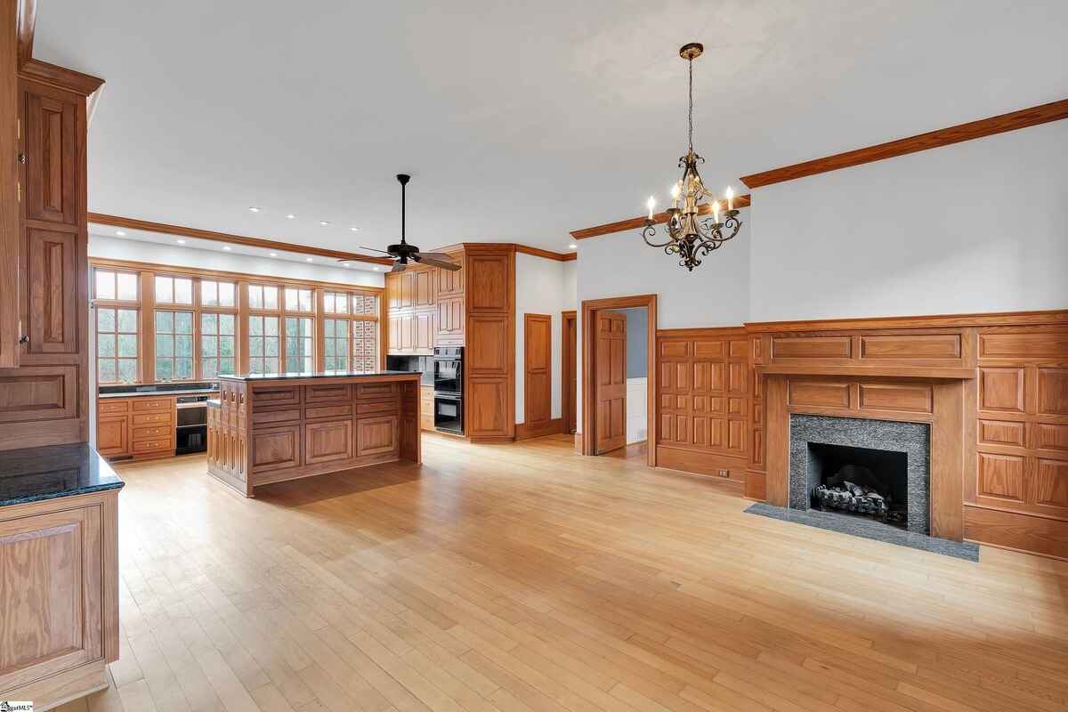 Large kitchen with rich wooden cabinetry, granite counters, and ample natural light.