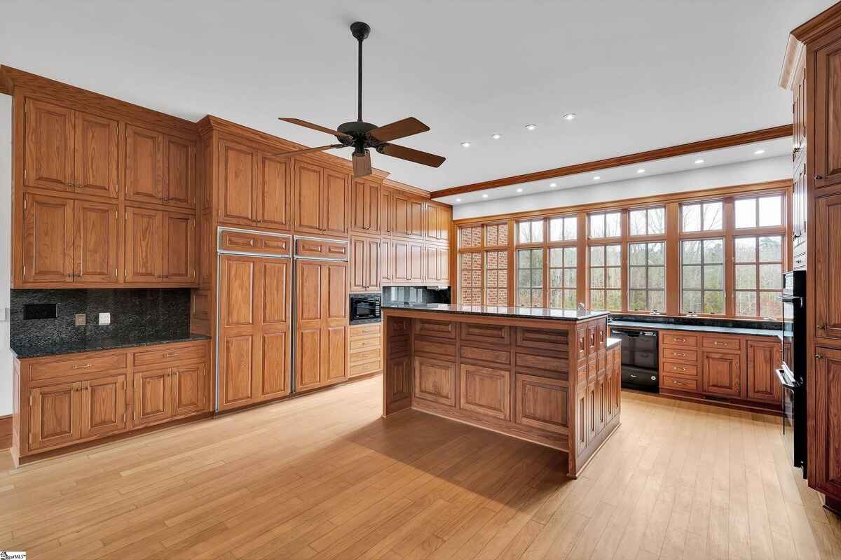 Wood-paneled family room with a central fireplace and elegant chandelier.