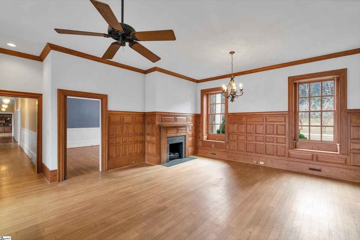 Study or library with warm wood paneling and exposed beams.