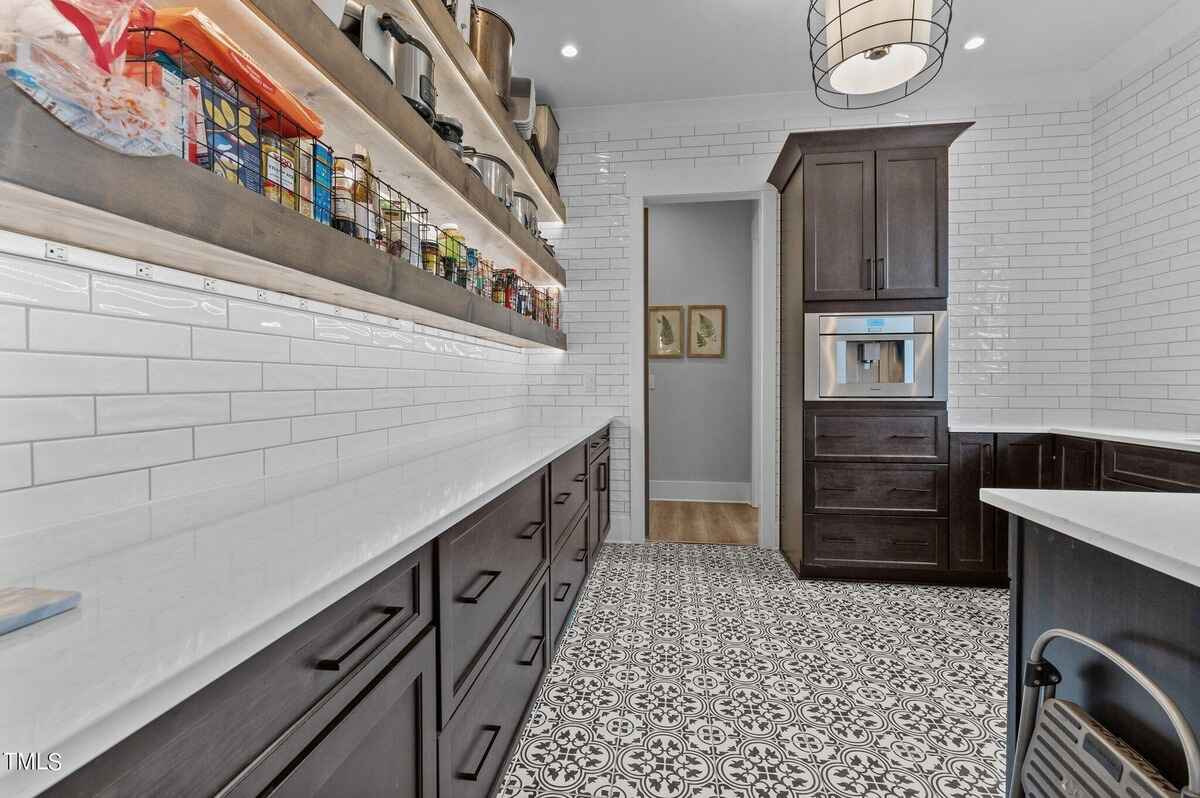 Well-organized pantry with ample storage and decorative tile flooring.