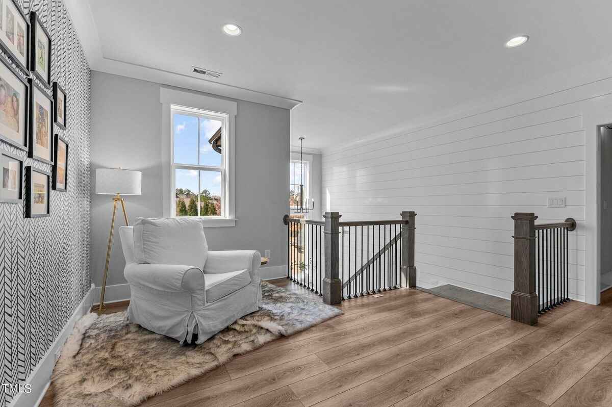 Cozy reading nook with an armchair, accent wall, and natural light from a window.