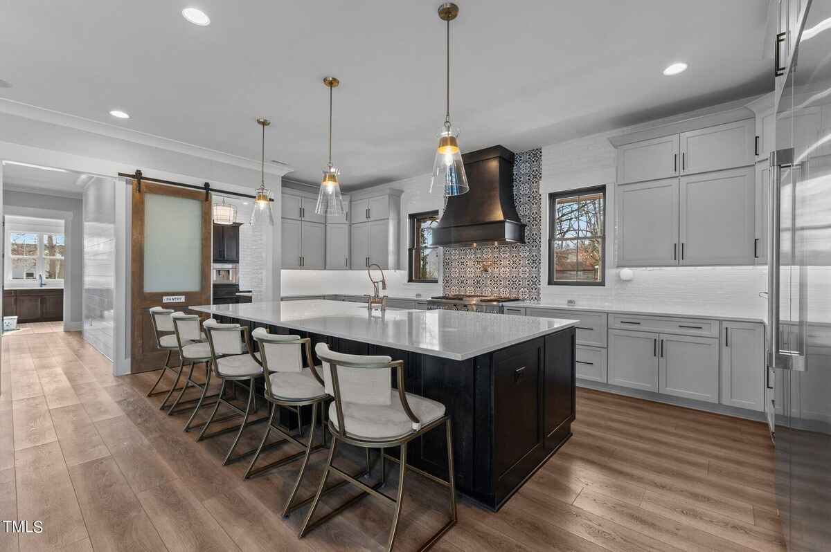 Contemporary kitchen with large island, pendant lighting, and modern cabinetry.