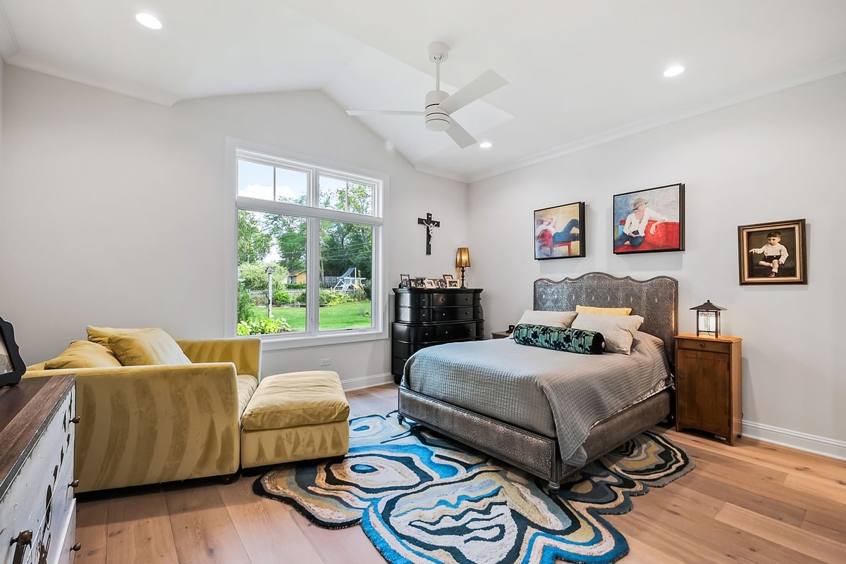 This expansive guest bedroom, captured from a wide-angle perspective, exudes an air of sophisticated elegance.