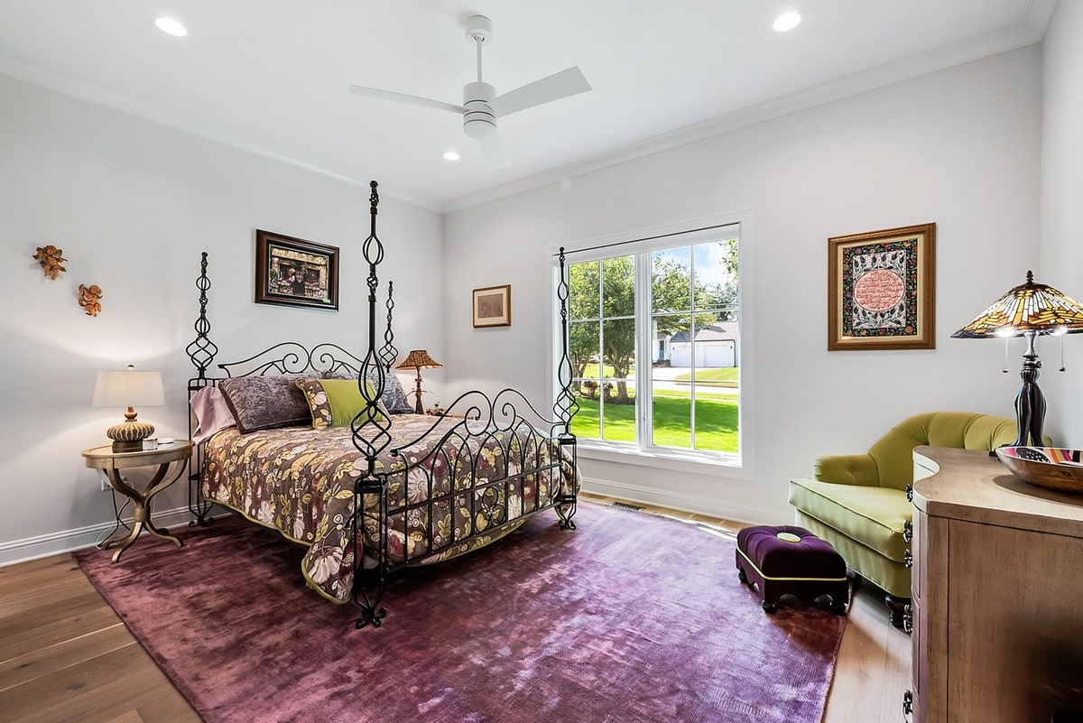 This expansive guest bedroom, captured from a wide-angle perspective, exudes an air of sophisticated elegance. 