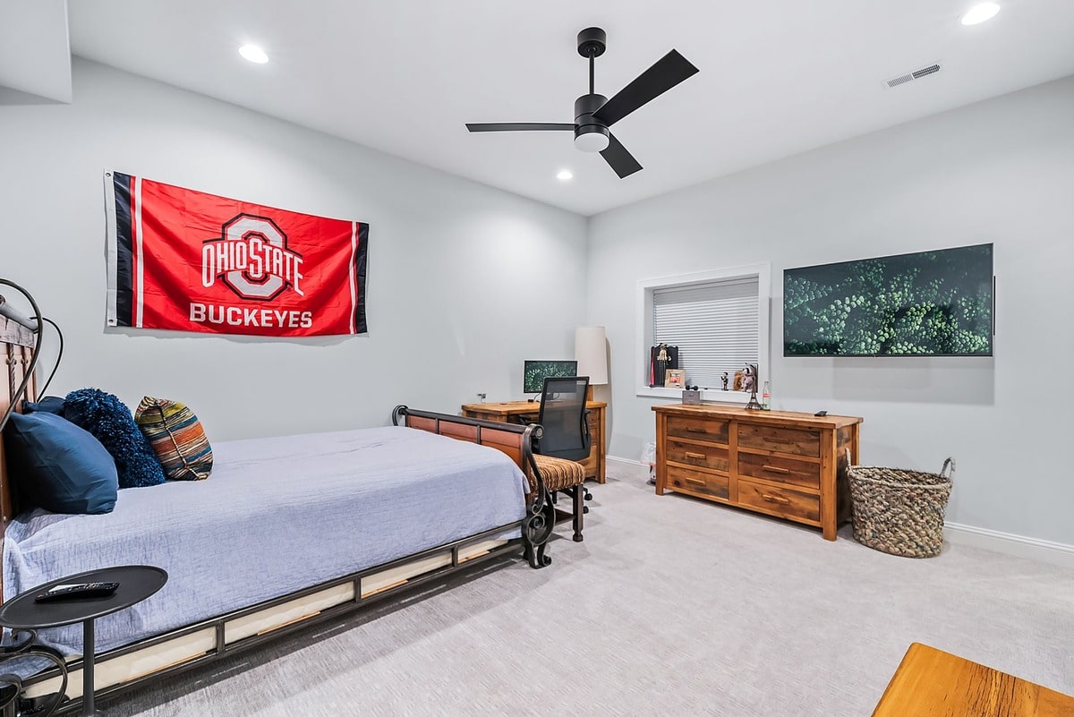 This expansive basement bedroom, captured from a wide-angle perspective, exudes an air of sophisticated elegance.