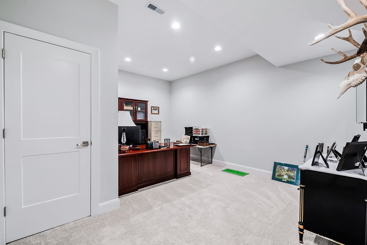 This expansive basement office, captured from a wide-angle perspective, exudes an air of sophisticated elegance. This expansive basement office, captured from a wide-angle perspective, exudes an air of sophisticated elegance. 