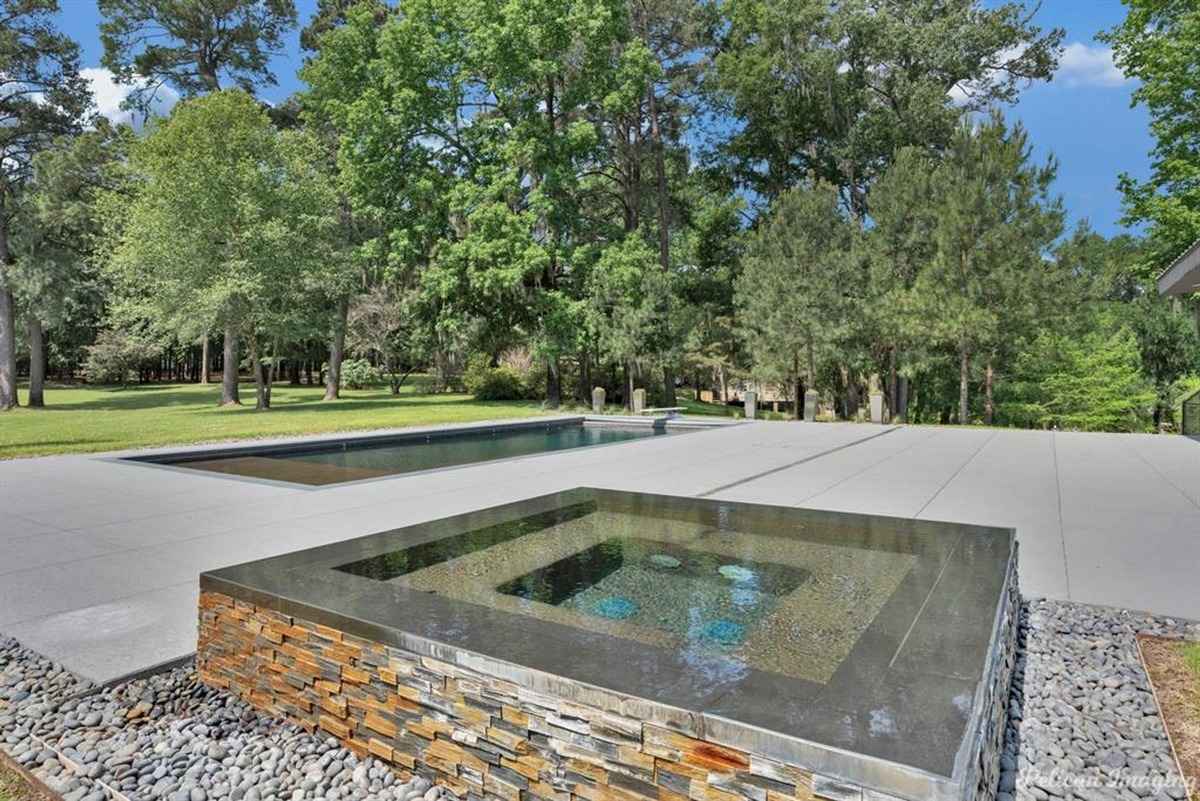 A modern water feature with clean lines and a reflecting pool surrounded by nature.