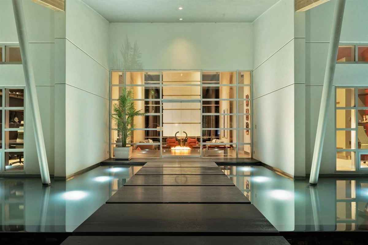 A sleek entryway with a water feature and a walkway leading to the interior.