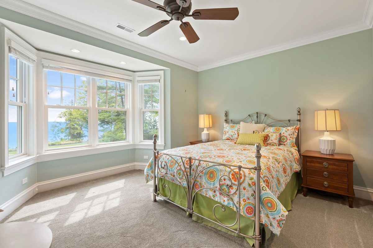 A cozy bedroom with a bay window and a cheerful, colorful design.