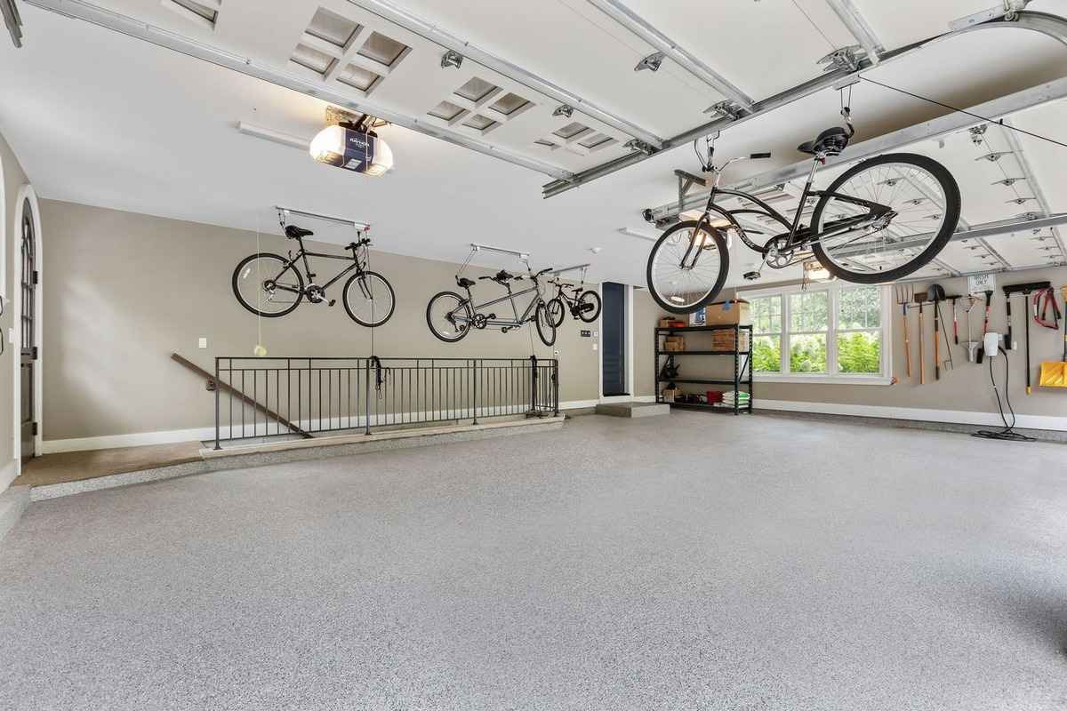 A spacious, organized garage with suspended bike storage and ample workspace.