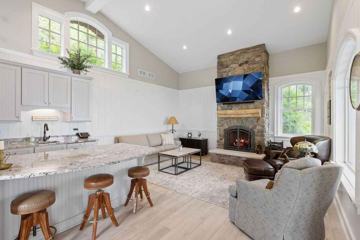 A rustic-style kitchen with granite countertops, wooden cabinetry, and a lake view.