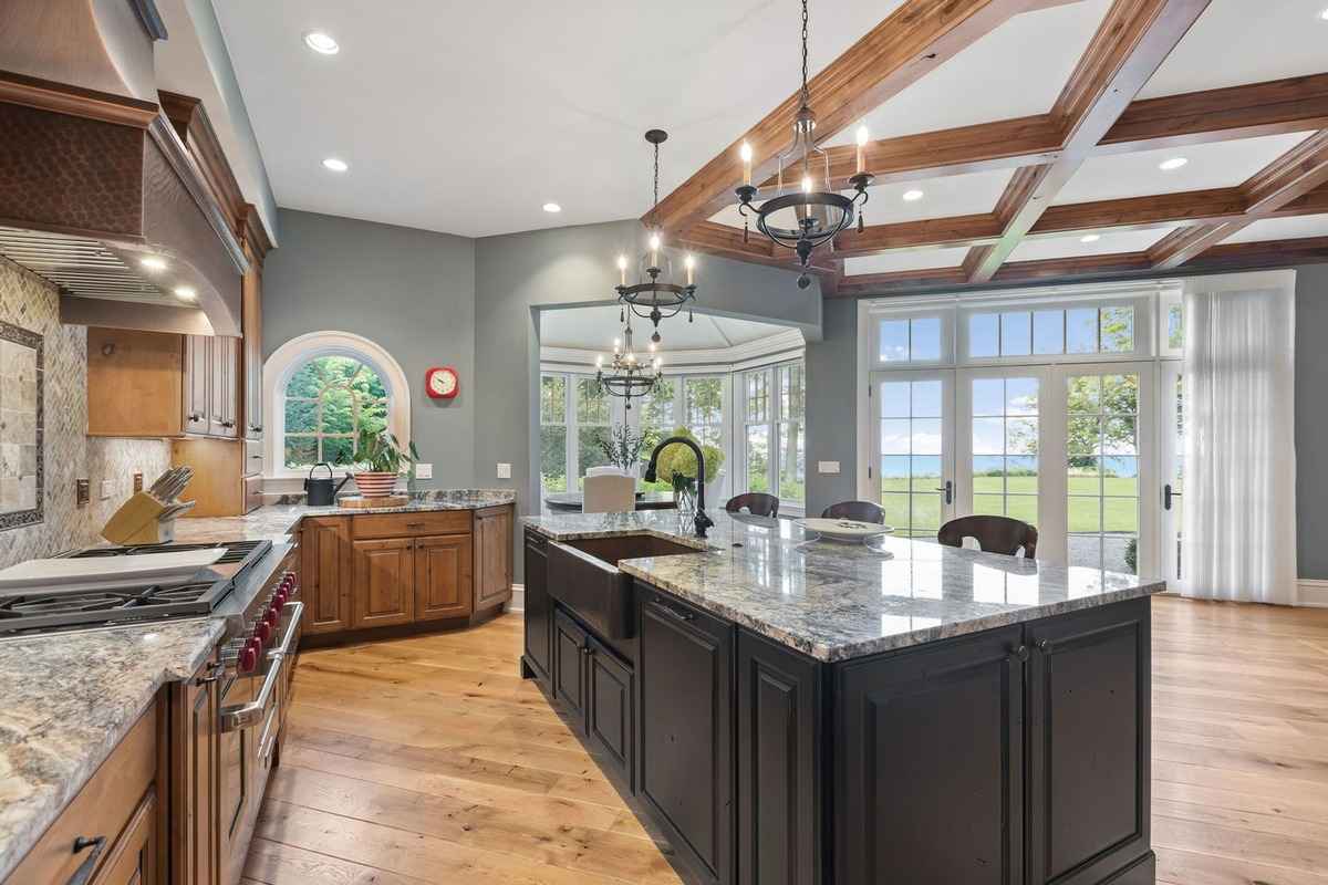 A luxurious kitchen with granite countertops and a large island, overlooking a scenic view.