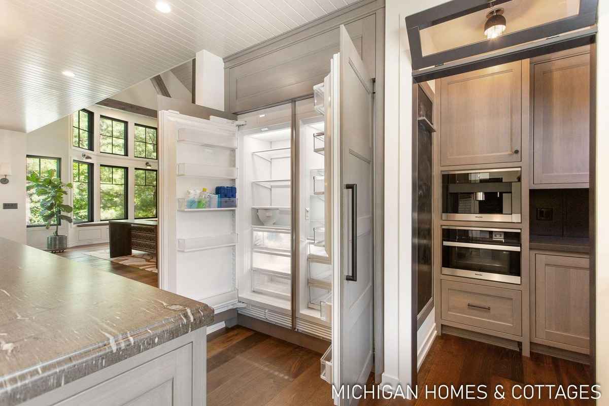 A kitchen features a large built-in refrigerator and a pantry area with built-in appliances.