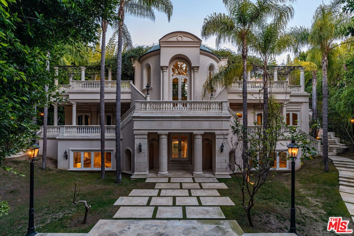 Mansion house is light-colored, and the landscaping includes palm trees. The overall style is grand and formal.