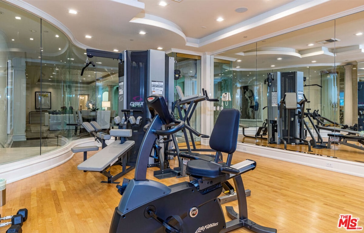 Home gym with various pieces of exercise equipment, including stationary bikes and weight machines.