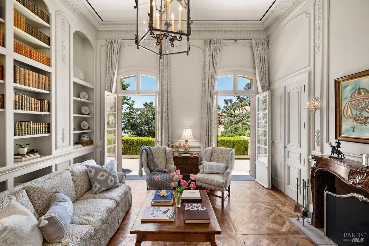 The room is dominated by built-in bookshelves with a large French door 