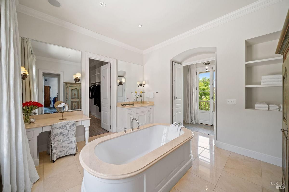 Bathroom with a freestanding bathtub and features light colored walls and flooring