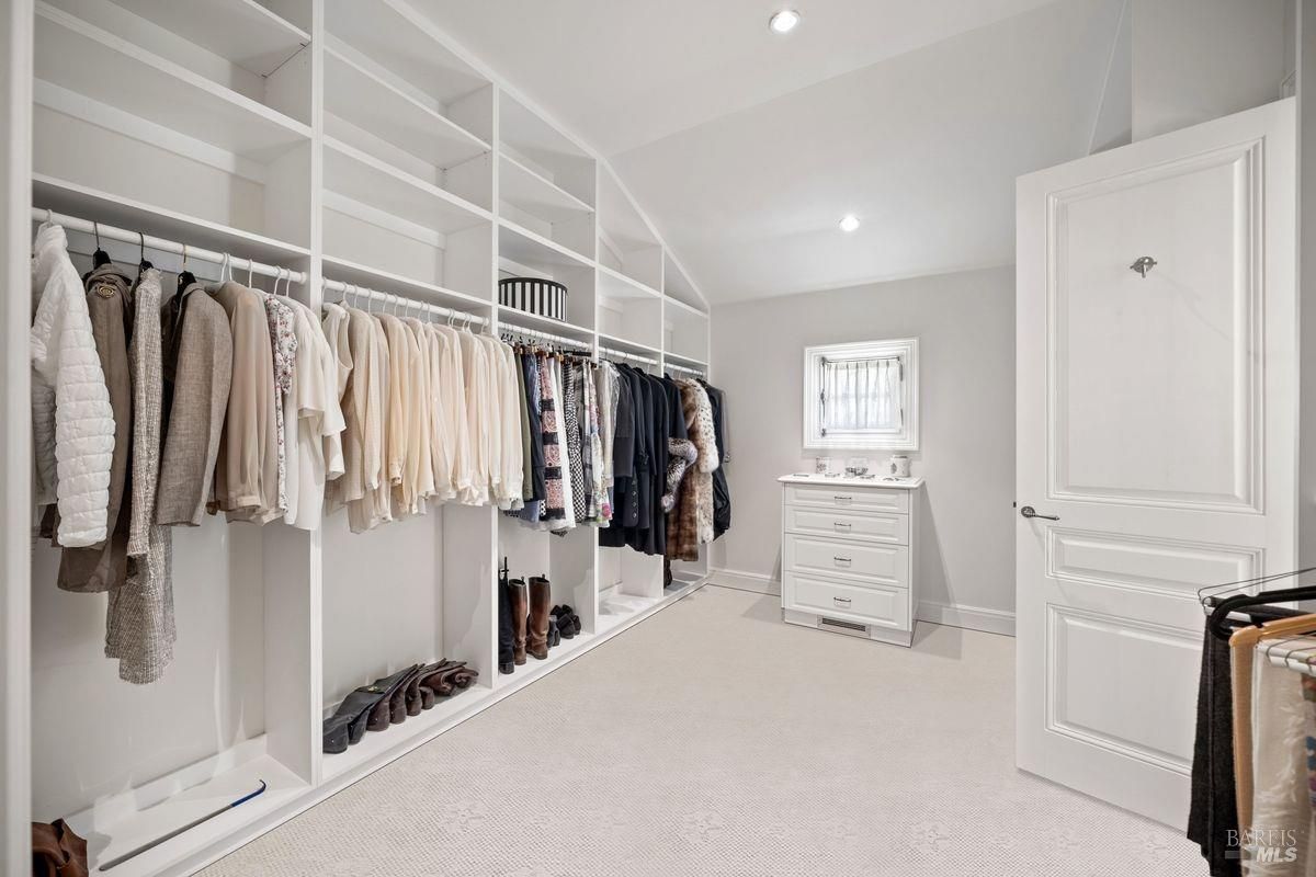 Well-organized walk-in closet with extensive built-in shelves 