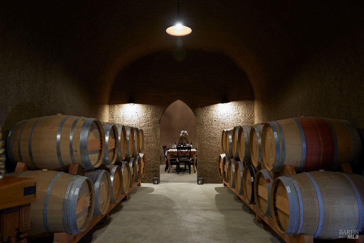 Interior of a wine cellar with rows of wooden wine barrels are stacked along the walls