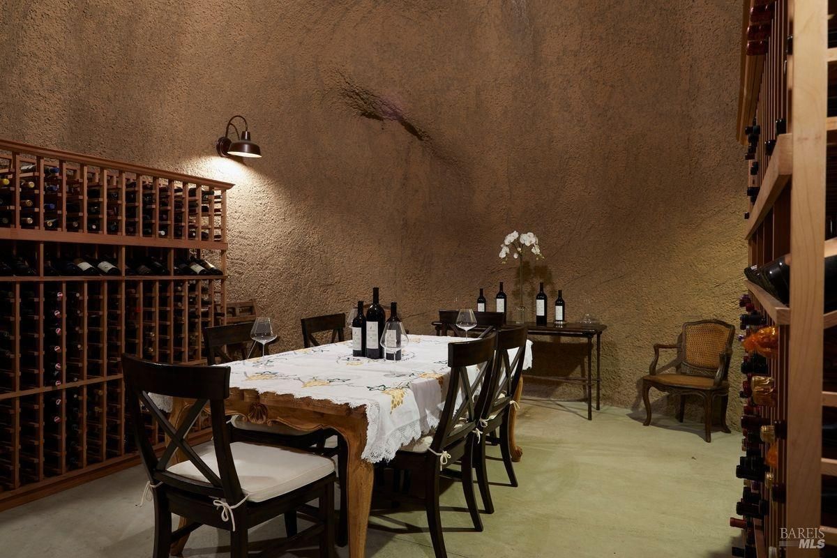 A long table is set for a wine tasting with wine bottles and glasses