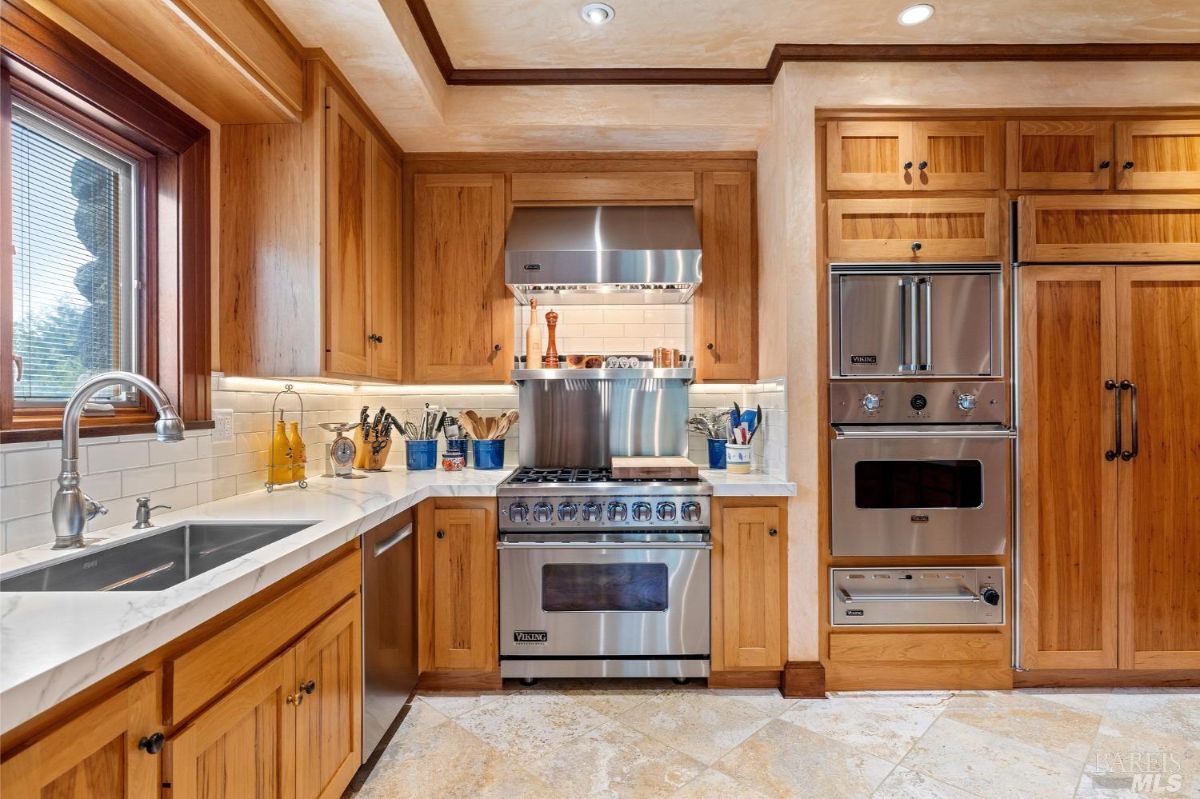 Modern kitchen corner featuring stainless steel appliances, wooden cabinetry, and ample counter space.