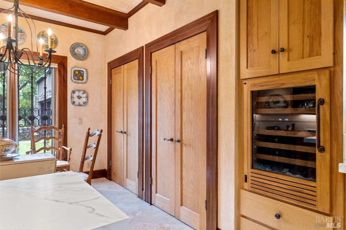 Cozy dining area with a compact table, decorative plates, and double pantry doors for additional storage.