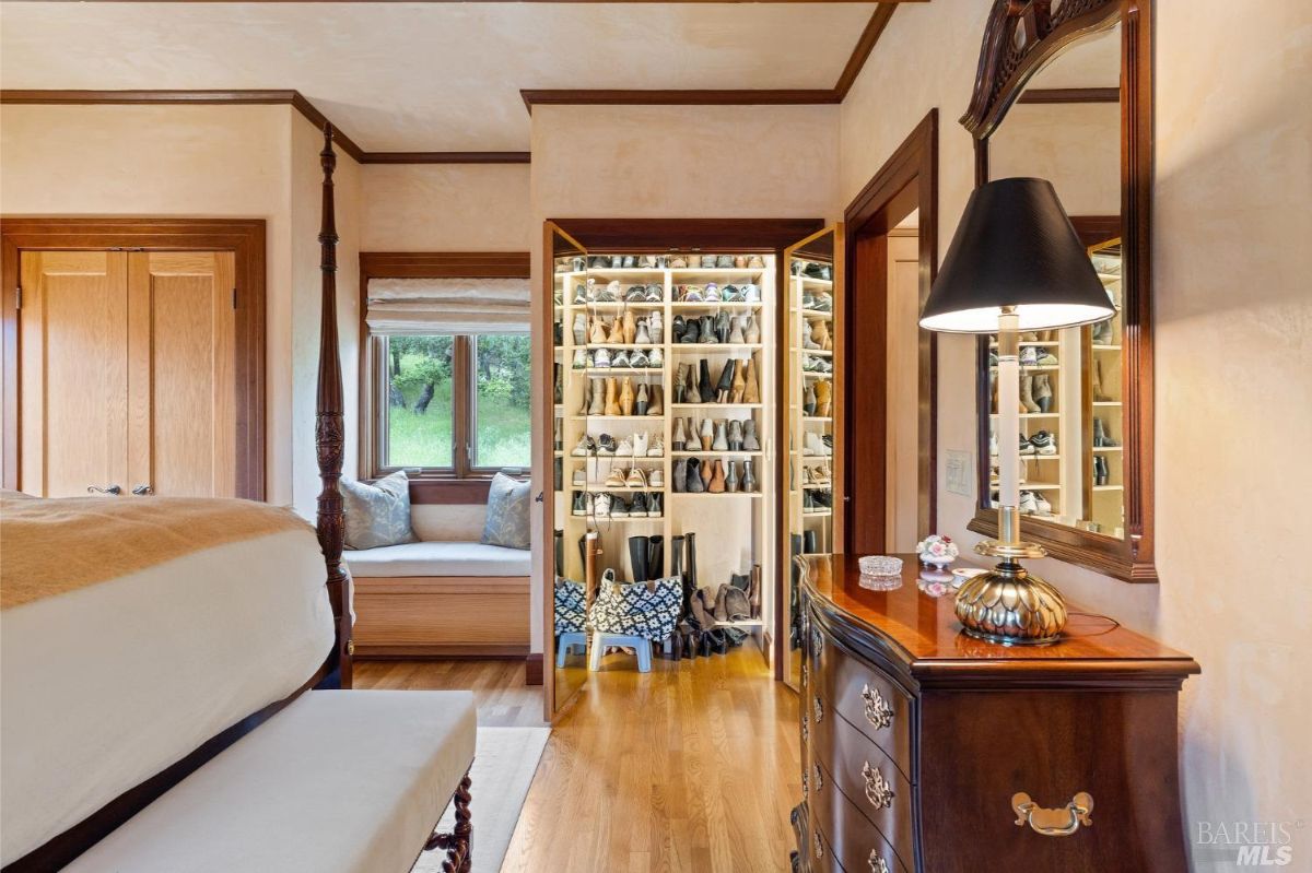 Walk-in shoe closet with well-organized shelving and a view of the master bedroom.