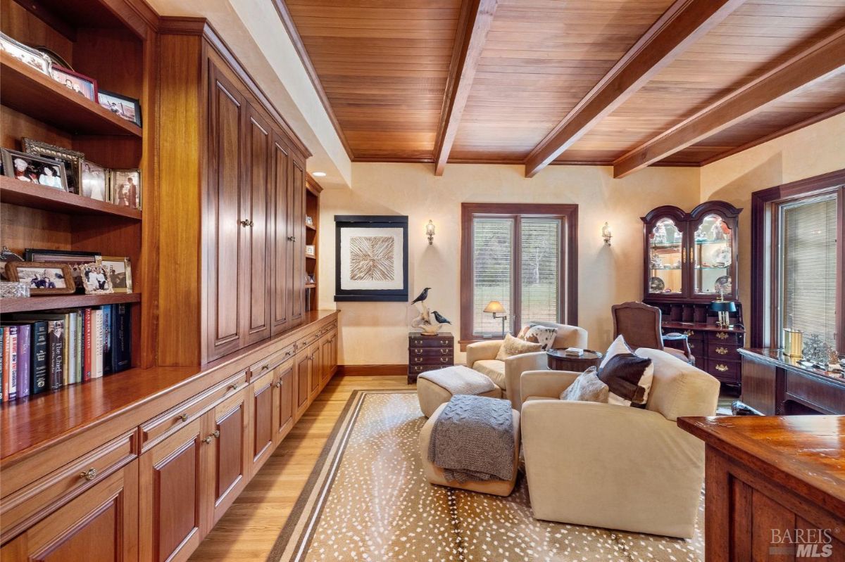 A cozy seating area flanked by custom wood cabinetry and natural light from large windows.