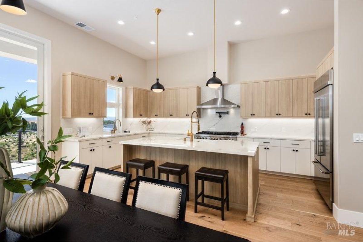 Modern kitchen with a central island, pendant lights, and luxury appliances.