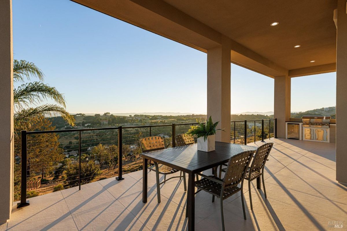 Patio has a built-in grill, table with chairs, and a view.