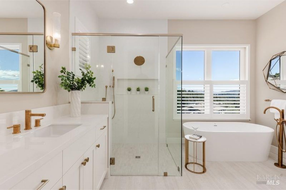 Elegant bathroom with a walk-in glass shower, a freestanding bathtub, and gold fixtures adding a luxurious touch.