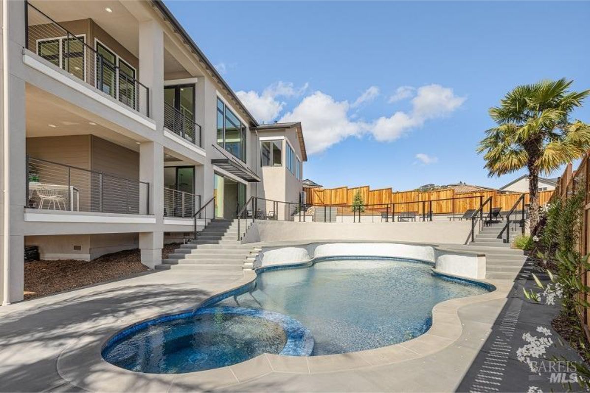 Swimming pool with a spa and a raised deck area.