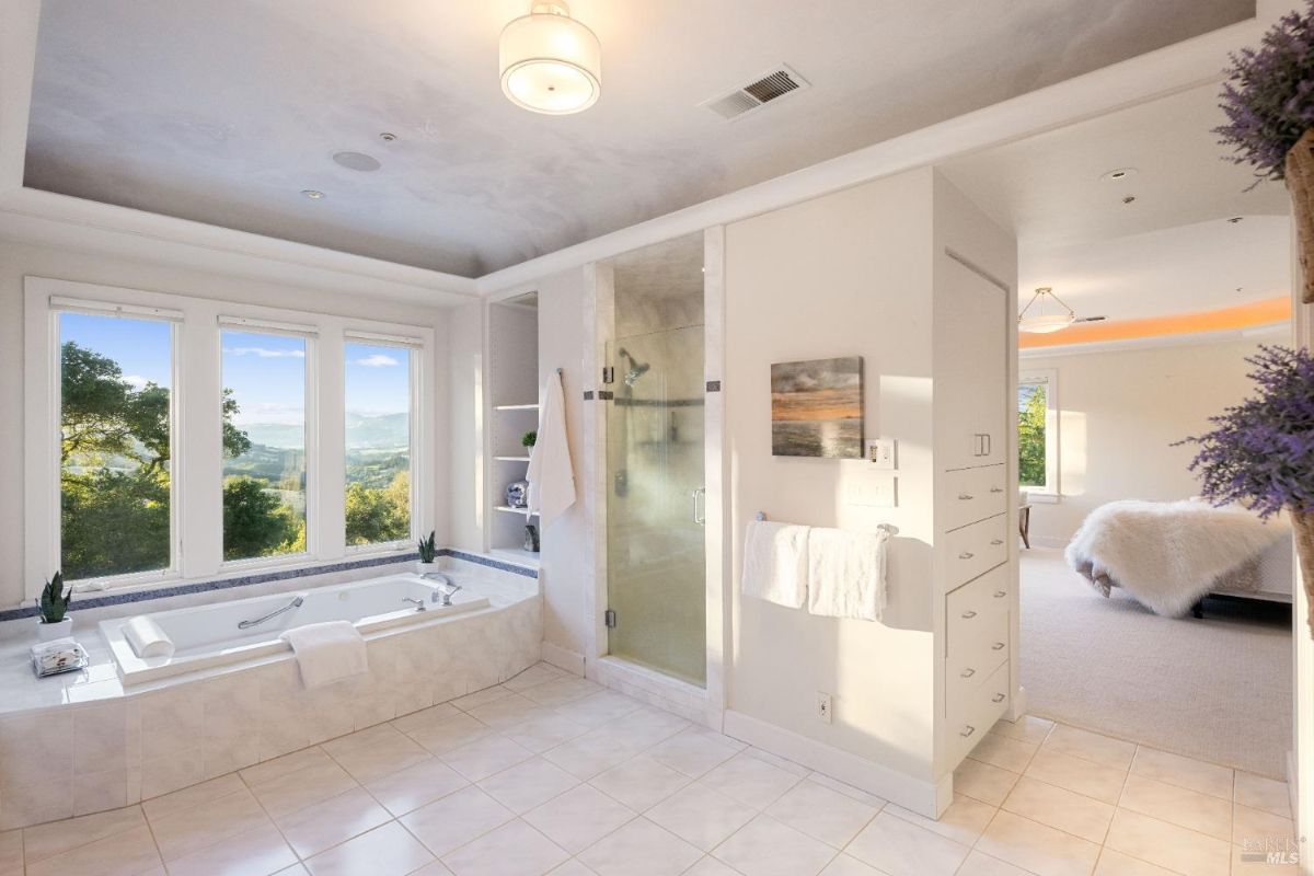 Luxurious bathroom with a walk-in shower, soaking tub, and stunning outdoor views.