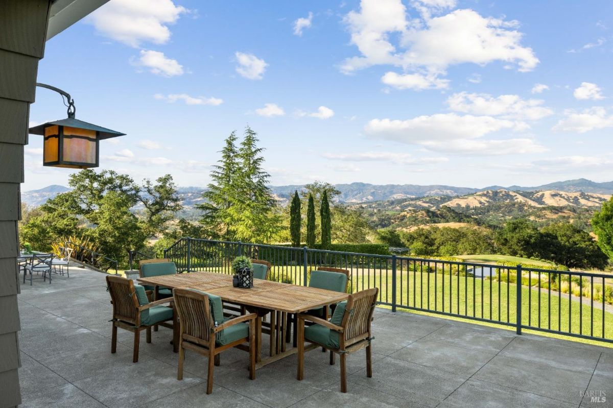 Outdoor dining patio offering panoramic views of rolling hills and lush landscapes.