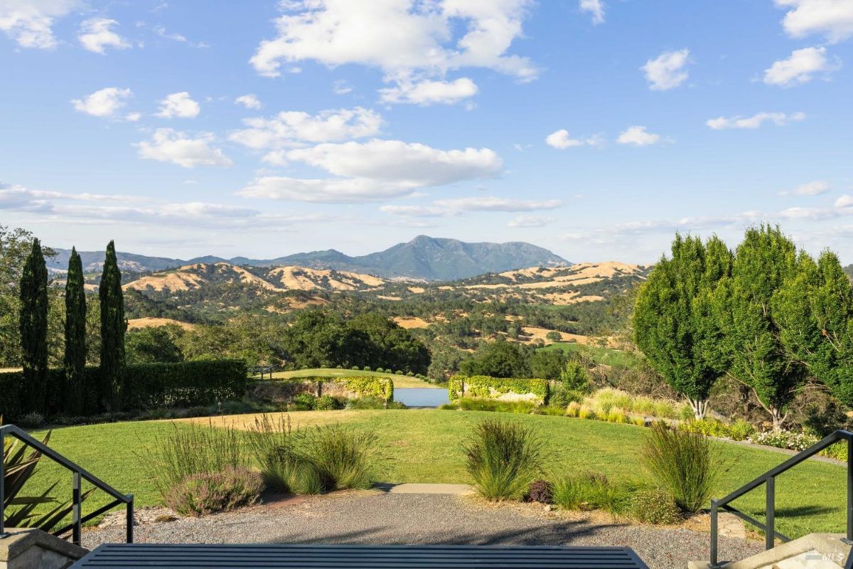 Garden pathway leading to a lush lawn and scenic landscapes beyond.