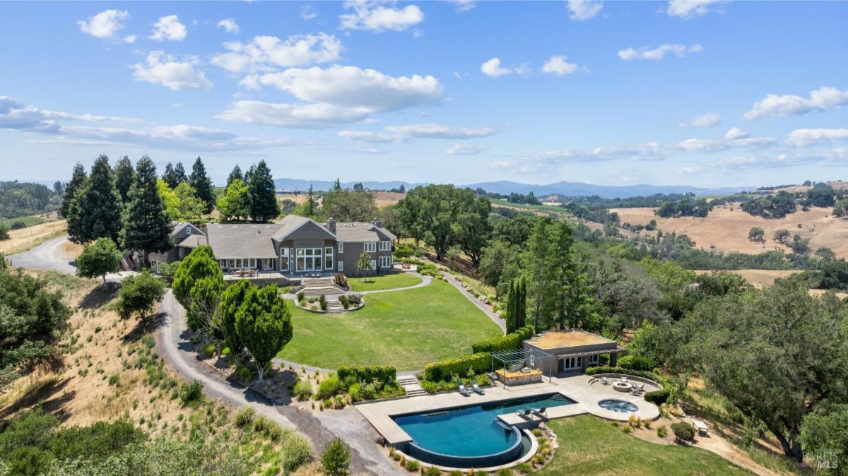 A panoramic view highlights the estate's stunning architecture nestled within rolling hills.