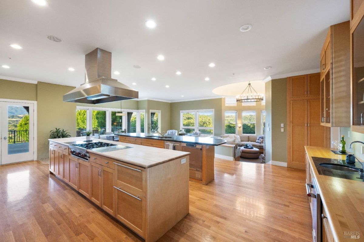 Spacious kitchen with a central island, stainless steel appliances, and views of the surrounding greenery.