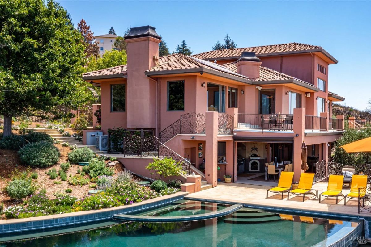 Two-story Mediterranean-style home with landscaped surroundings and a swimming pool.