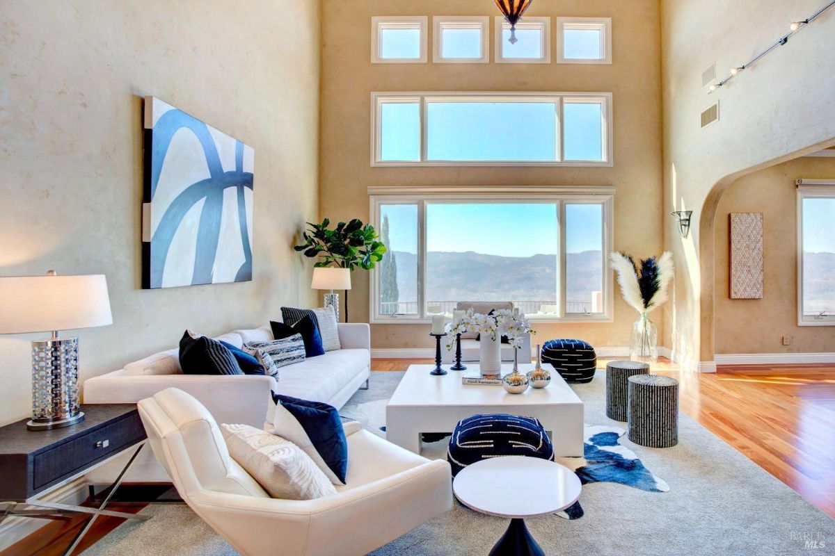 Living room featuring large windows, modern furniture, and mountain views.