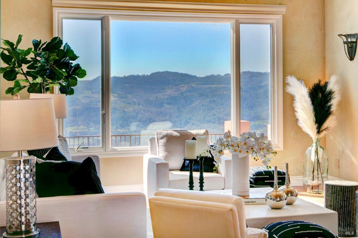 View through large windows showcasing a scenic mountain range with interior seating.