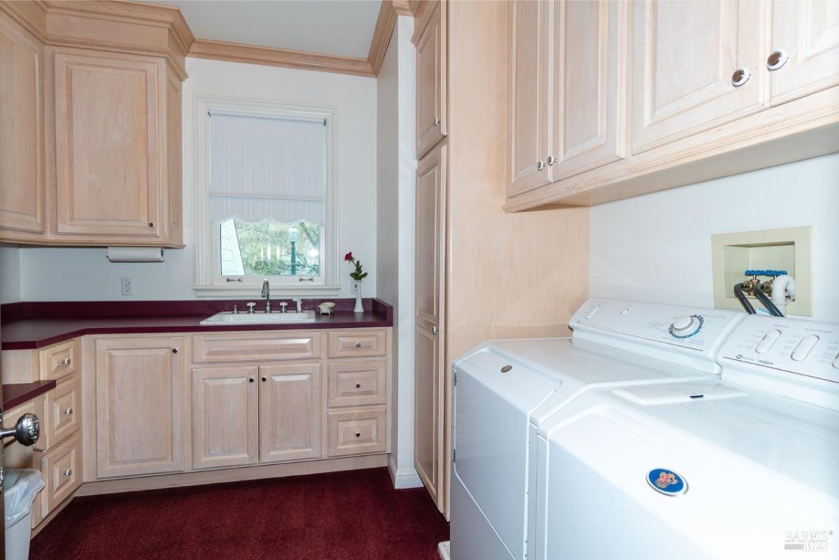 Spacious laundry room with white appliances and plenty of cabinetry.