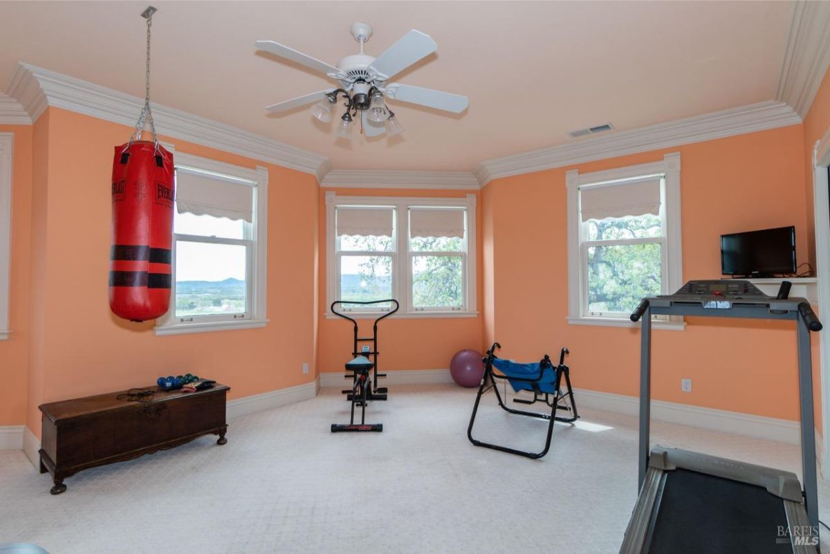 Bright workout room with exercise equipment and a hanging punching bag.