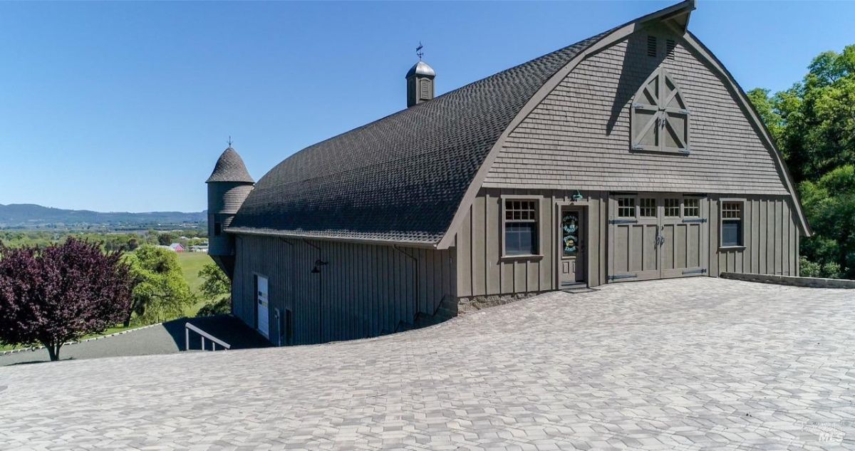 Barn-style building with a distinctive curved roof and tower.