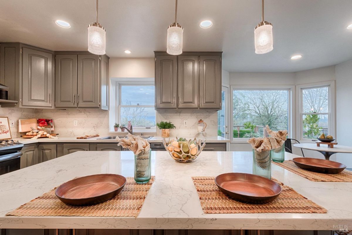 Kitchen island with plates, a bowl, and a view of a landscape.