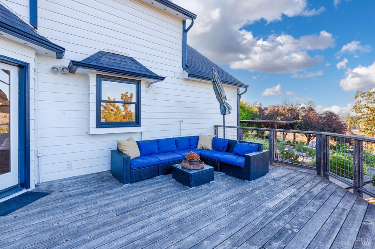 Wood deck with a blue sectional sofa and a view of the landscape.