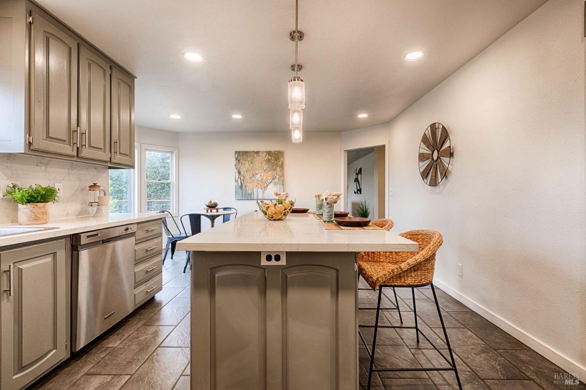 Kitchen with an island, cabinets, and a dining table.