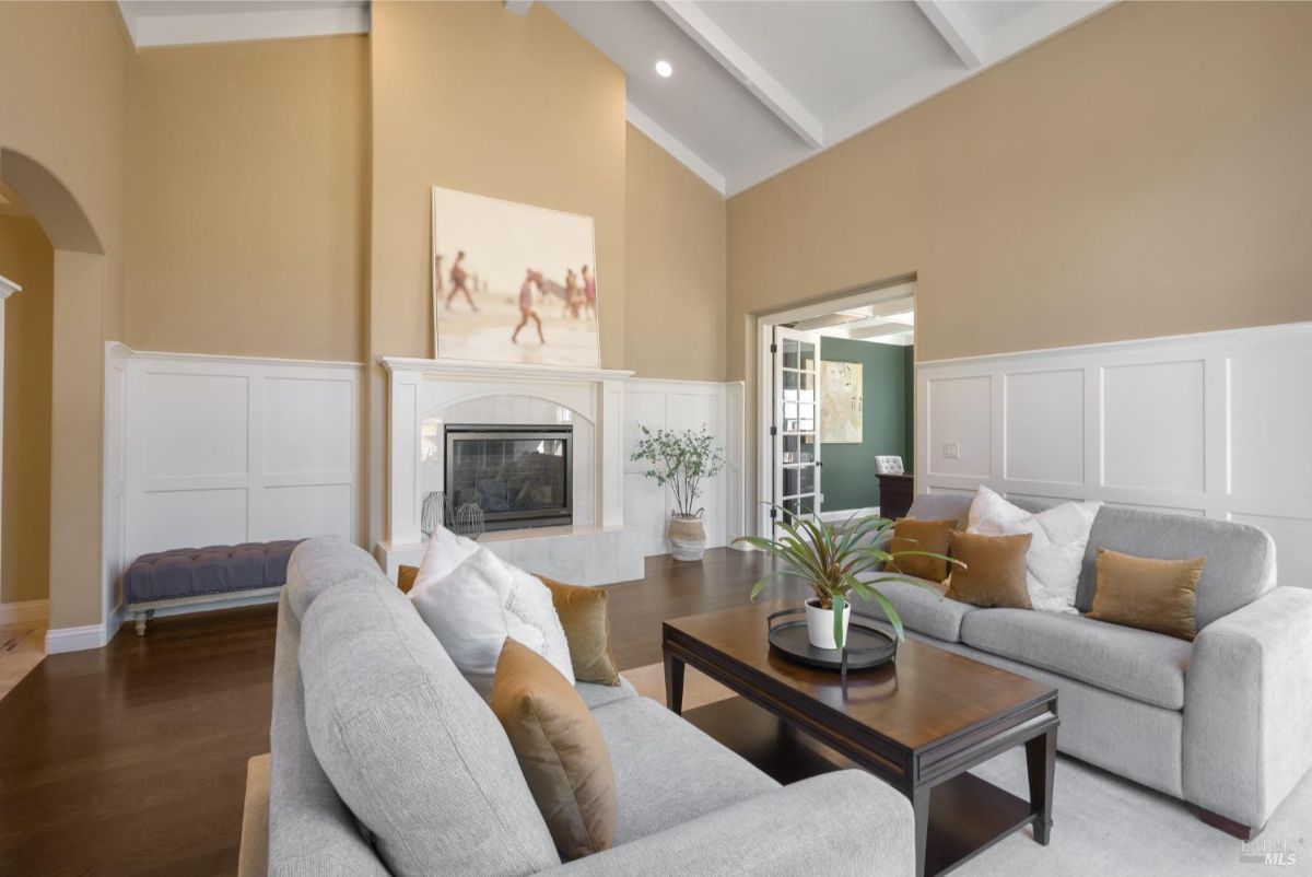 Spacious sitting area with a cozy fireplace and neutral-toned furniture complementing high ceilings.