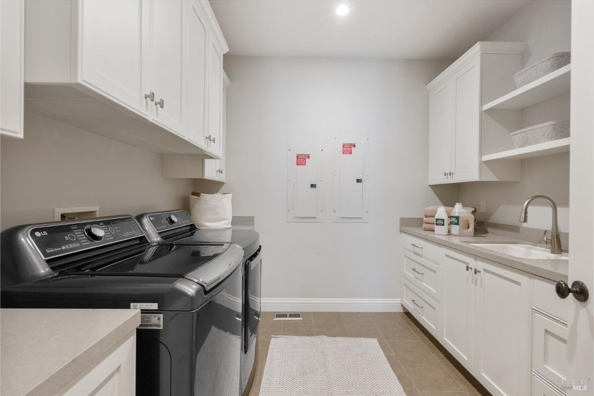 The laundry room features a washer, dryer, folding counter, and a sink.